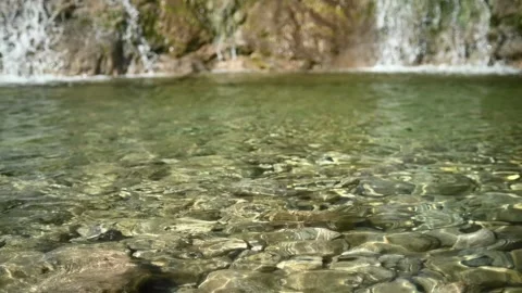 Waves and sunlight effects in the pool created by a waterfall (slow motion) Stock-Footage 219645272