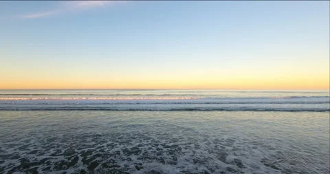 Waves and surf break towards Horizon. 4k Aerial Stock Footage 145236604