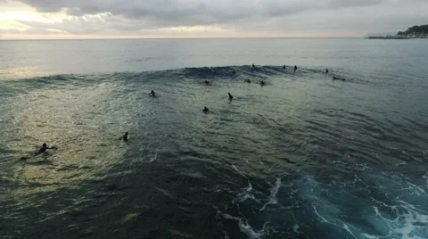 Waves and surfers in the ocean at sunset. Aerial drone video N. Stock Footage 63803570