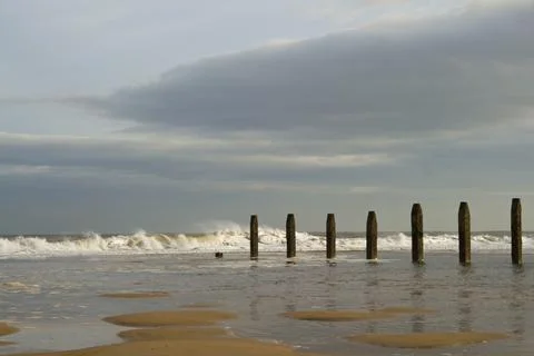 Waves approaching groynes Stock Photos