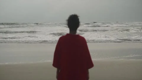The waves of the Arabic ocean at goa beach. The girl in the red dress is Stock Footage 244825400