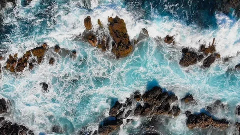 Waves are breaking on stones. Wave foaming and splashing ocean surf. Aerial top Stock Footage 124314769