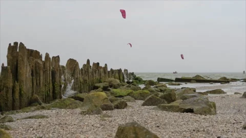 Waves are broken about a series of old wooden pillars on which erosion from the Stockbeeldmateriaal 95318938