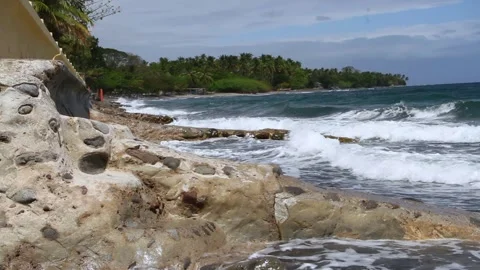 The waves are crashing in on the rocks on the beach in Malatapay Video stock 265154996