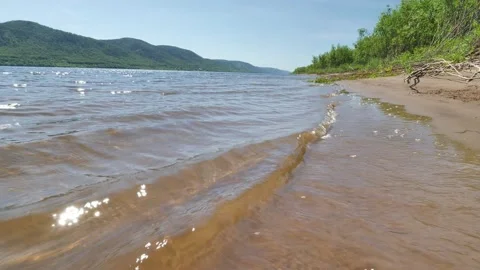 Waves are rushing onto the sandy shore. river Volga. Stock Footage 203177540