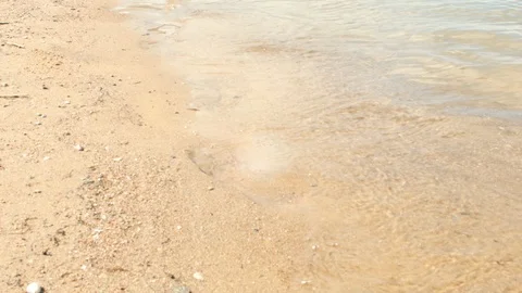 Waves are sliding over the sandy shore in 4K Stock Footage 98951490