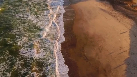 Waves arrive on the beach of Namibia in the rays of the African sunset. Video stock 77506397
