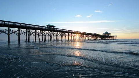 Waves in the Atlantic Ocean and the pier at sunrise, at Folly Beach Stock Footage 71628276