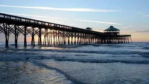 Waves in the Atlantic Ocean and the pier at sunrise, at Folly Beach, near Charle Stock Footage 71628893