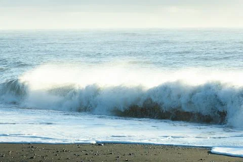 The waves of the atlantic ocean are lapping on the volcanic black beach, Icel Stock Photos