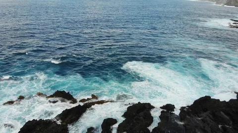 Waves of the Atlantic ocean beat against the rocky shore, black volcanic sand Stock Footage 102304080
