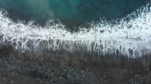 Waves of the Atlantic ocean beat against the rocky shore, black volcanic sand Stock Footage 102304752