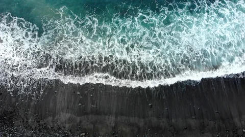 Waves of the Atlantic ocean beat against the rocky shore, black volcanic sand Stock Footage 102305162