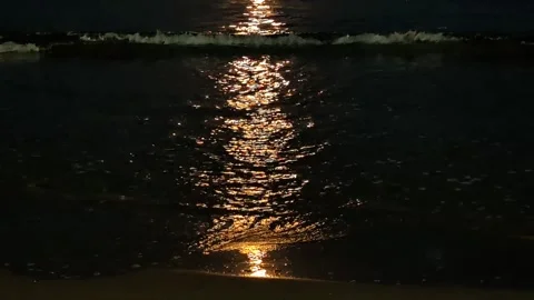 The waves, bathed in a full moon golden color, slide towards the sandy beach. Stock Footage 305276581