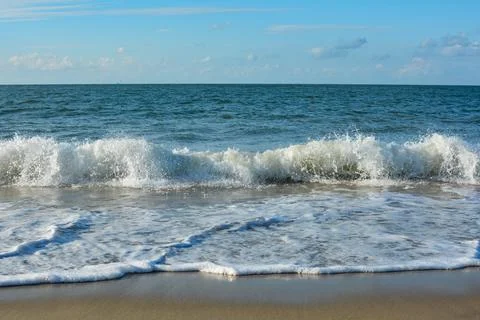 Waves on beach with blue sky Stock Photos