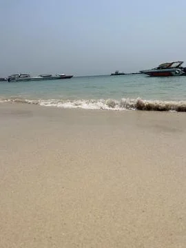 Waves on the beach with boats Stock Photos