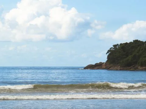Waves on the beach with island in the background. Stock Photos