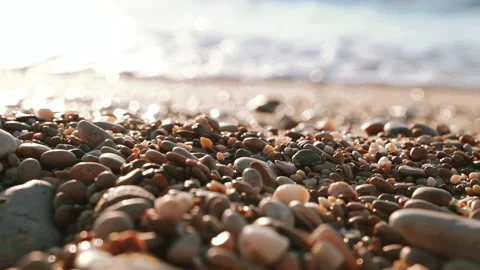 Waves on the beach with pebbles at sunset, the sun goes into the water Stock Footage 162247431