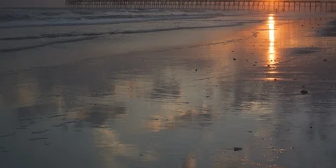 Waves on the beach with pier in background at sunset. NC Stock Footage 103492314