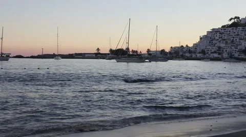 Waves on beach with sailboats at sunset Stock Footage 1072190