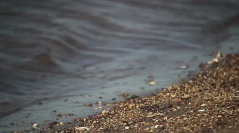 Waves on the beach, small rocks/pebbles Видео 46134730