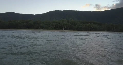 Waves onto beach at sunset Stock Footage 141585834