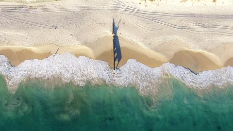 Waves on a beach at sunset near storm drain aerial footage hovering Stock Footage 108656653