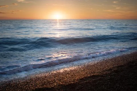 Waves on the beach at sunset Stock Photos