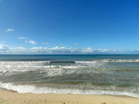 Waves on the beach under blue sky Stock Photos