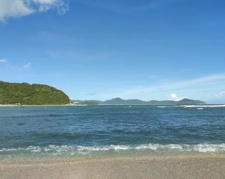 Waves on the beach under blue sky Stock Photos