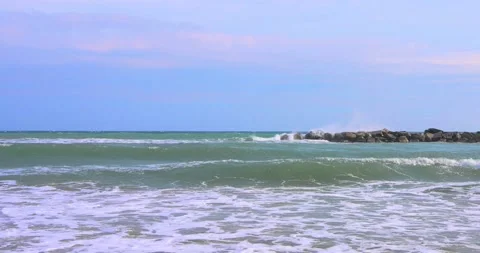 Waves on the beach under a sky with light clouds Stock Footage 213236322