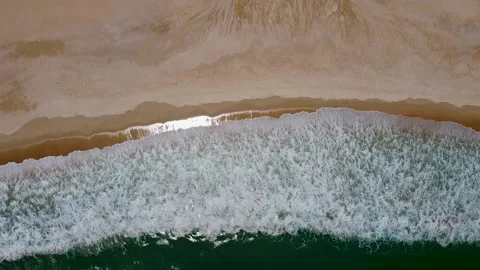 The waves beat beautifully on the sandy beach, leaving patterns Stock Footage 166055563