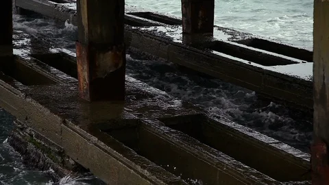 WAVES BEAT ON THE FOUNDATION OF THE OLD PIER, rust, cloudy Stock Footage 114631380