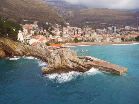 Waves beat on  pier next to cliff aerial view Vidéo 74628439