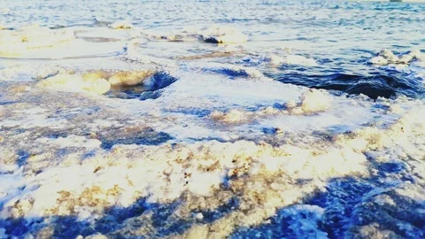 Waves beating against the shore of salt crystals. slow motion Stock Footage 108898953