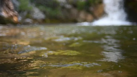 Waves on a beautiful pool of a waterfall in summer (bokeh, slow motion) 스톡 동영상 219388124
