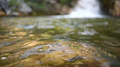 Waves on a beautiful pool of a waterfall in summer (bokeh, slow motion) Stock Footage 219820681