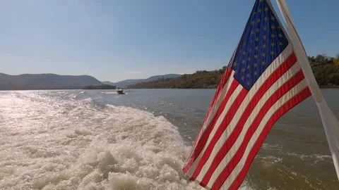 Waves behind a boat on a river with an American flag Stock Footage 300046260