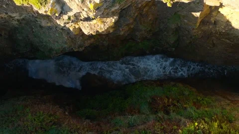 Waves Between The Rocky Cliffs Of Hole - aerial ascend 動画素材 254018173