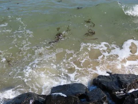 Waves on black rocks Stock Photos