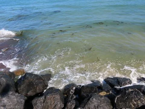Waves on black rocks Stock Photos