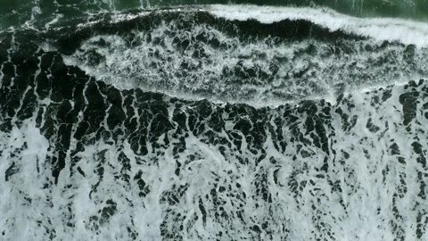 Waves on black sand beach in Bali. Slow motion. Drone view Stock Footage 246614097