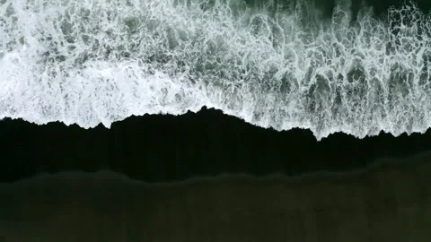 Waves on black sand beach in Bali. Slow motion. Drone view 動画素材 246660285
