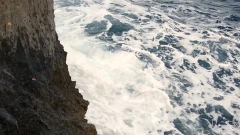 Waves in the blue sea hitting the rocks in slow motion Stock Footage 130294547