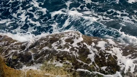 Waves in the blue sea hitting the rocks in slow motion Stock Footage 130294550