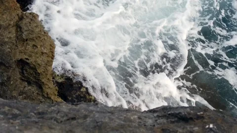 Waves in the blue sea hitting the rocks in slow motion Stock Footage 130294554