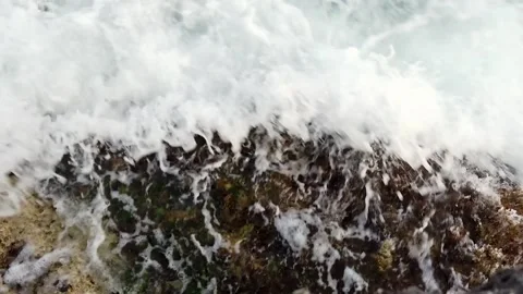 Waves in the blue sea hitting the rocks in slow motion Stock Footage 130294571
