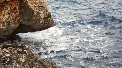 Waves in the blue sea hitting the rocks in slow motion Stock Footage 130294573