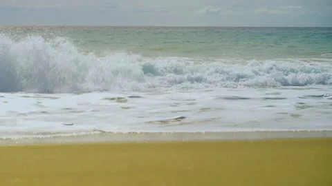 Waves of the blue sea run into the yellow sand Stock Footage 239545814