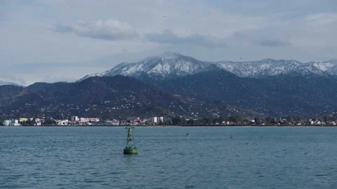 The waves of the blue strait shake the float. Seagulls fly by the sea in Georgia Stock Footage 139408767